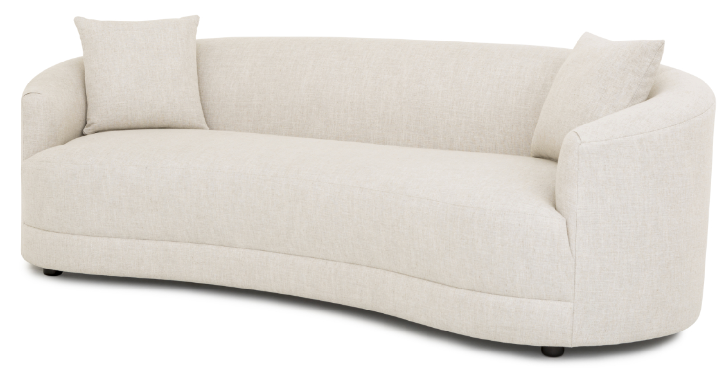 A beige Sorrento sofa with a modern design, including a rounded shape and elegant curves. It is displayed with cushions on it and has a sleek silhouette.