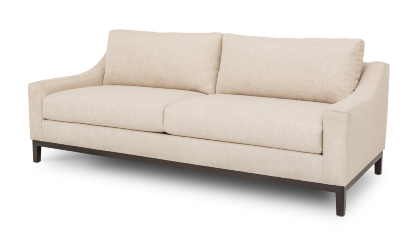 A beige Vienna sofa with a tailored silhouette, featuring a low-profile design, wide seat, and visible wooden legs.